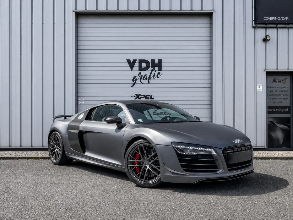 Coupé sport Audi TT (2e génération, MK2) bleu métallisé brillant, garé devant deux portes de garage blanches